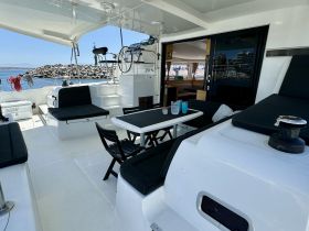 A spacious interior view of a boat's dining area, featuring comfortable seating and a well-equipped cabin, perfect for relaxing during a day on the water.