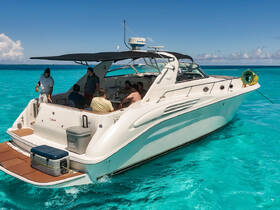 A lively group enjoys their time aboard a yacht in stunning turquoise waters, perfect for a day of relaxation and celebration on the water.