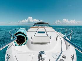 A stunning view from the front of a yacht cruising through clear blue waters, showcasing the vessel's sleek design against a picturesque sky.