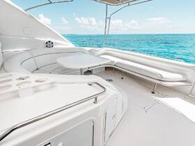 A stylish interior view of a boat's lounge area, featuring comfortable seating and a table, perfect for relaxing while enjoying the scenic ocean views.