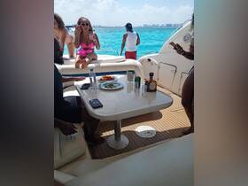 A lively group enjoys drinks and snacks aboard a yacht, capturing the essence of a fun day on the water with friends.