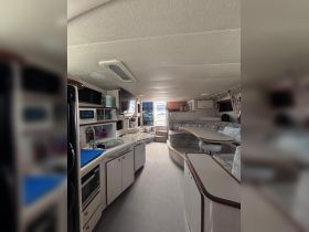 Interior view of a spacious boat cabin featuring a well-equipped kitchen and comfortable seating area, perfect for relaxing during your nautical adventures.
