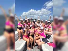 A lively group of friends celebrates on a boat, enjoying drinks and sunshine — perfect for bachelorette parties or summer gatherings on the water.