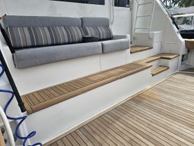 A cozy seating area inside the boat, featuring stylish cushions and wooden steps, perfect for relaxation while cruising.