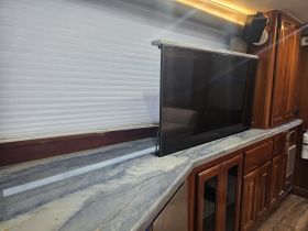 A sleek interior view of a boat's cabin featuring a modern countertop and television setup, perfect for relaxation and entertainment while on the water.