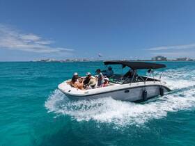 A lively group enjoys a day on the water aboard a speedboat, making memories in the beautiful turquoise sea — perfect for family outings or celebrations.