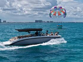 A lively scene featuring a group enjoying a day on the water, with a parasail in the background — perfect for adventure seekers and fun-filled outings.
