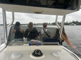 A group of friends enjoys a scenic boat ride, capturing the moment as they take in the views from the deck. Perfect for memorable outings on the water.