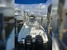 A well-maintained center console boat docked at the marina, showcasing its sleek design and twin engines, perfect for fishing or day trips on the water.