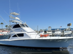 A sleek yacht docked at the marina, showcasing its elegant design and structure against a clear blue sky.