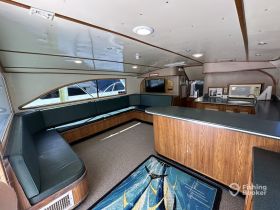 Interior view of a spacious boat cabin featuring comfortable seating and a well-equipped galley area, perfect for relaxing during trips on the water.