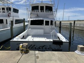 A clear view of the stern of the 'Ballistic II' yacht docked in Panama City, showcasing its sleek design and spacious rear deck.
