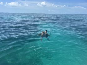 A couple enjoys a refreshing swim in the crystal-clear waters, showcasing the beauty of a perfect day on the water.