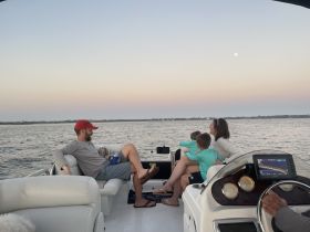 A family enjoys a serene sunset on a boat, creating lasting memories together — perfect for family outings and special moments on the water.