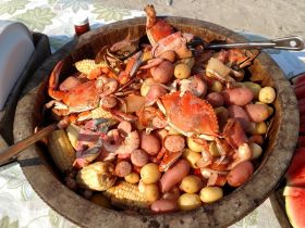 A delicious seafood feast featuring crabs, shrimp, and potatoes, perfect for enjoying on a boat trip or beach outing.