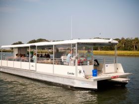 A lively group enjoys a scenic cruise aboard the Caretta, perfect for family outings or group adventures on the water.