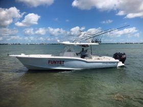 A fishing boat named 'Octan Master' is anchored in clear waters, showcasing its sleek design and fishing gear — perfect for charter adventures.