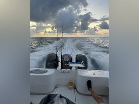 A dynamic view from the back of a speedboat, showcasing fishing rods against a stunning sunset backdrop — perfect for fishing enthusiasts on the water.
