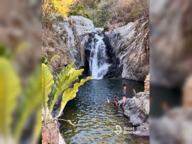 A group of friends enjoys a refreshing swim at a picturesque waterfall, surrounded by stunning natural scenery — perfect for adventure seekers and nature lovers.