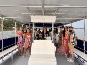A lively group of friends enjoys a fun celebration aboard a boat, showcasing the perfect atmosphere for parties and gatherings on the water.