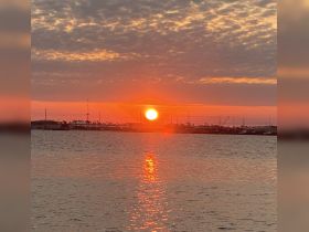 A stunning sunset over the harbor, reflecting vibrant colors on the water — a perfect backdrop for evening boat trips or romantic getaways.