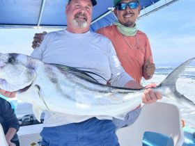 A successful fishing trip captured with a proud angler holding a large catch, showcasing the excitement of fishing adventures on the water.