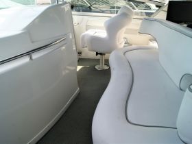 A well-appointed interior view of a boat's helm and seating area, showcasing comfortable furnishings ideal for relaxation and navigation.