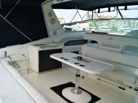A spacious interior view of a boat cabin featuring comfortable seating and a table, perfect for relaxing while on the water.