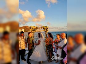 A beautiful wedding ceremony takes place on a boat at sunset, surrounded by loved ones — a perfect backdrop for unforgettable celebrations on the water.