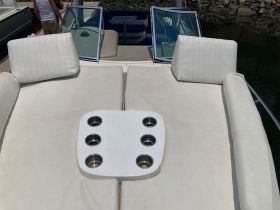 A cozy seating area on a boat featuring plush cushions and cup holders, perfect for relaxing on the water.