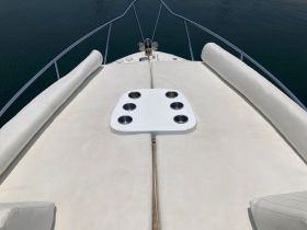 A close-up view of the seating area on a boat, featuring a stylish helm and cup holders, perfect for relaxing on the water.