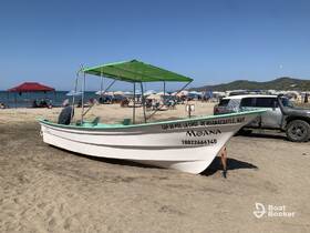 A picturesque view of the 'Moana' boat docked on the beach, surrounded by sunbathers and umbrellas, perfect for a day of relaxation by the sea.