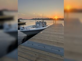 A sleek speedboat is docked at sunset, providing a picturesque view of the serene waters and surrounding scenery — perfect for evening cruises.