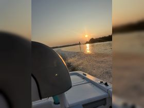A serene sunset view from the deck of a boat, showcasing the tranquil waters and the fading light of day — perfect for evening cruises.
