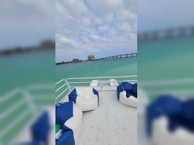 A cozy lounge area on a boat featuring comfortable bean bag seating, perfect for relaxing while enjoying the scenic views of the turquoise waters.