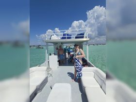 A lively group enjoys a sunny day on a boat, showcasing the fun and relaxation of a perfect day on the water.