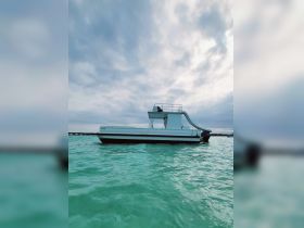 A sleek speedboat glides through clear turquoise waters, showcasing its modern design and inviting atmosphere for water adventures.