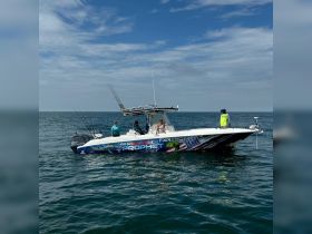 A group of anglers enjoys a day of fishing aboard a vibrant boat in the open ocean, showcasing the excitement of a fishing adventure.