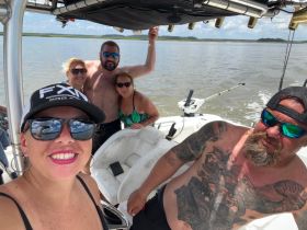A lively group of friends enjoys a fun day on the water, capturing memories aboard their boat. Perfect for showcasing the joy of boating adventures.