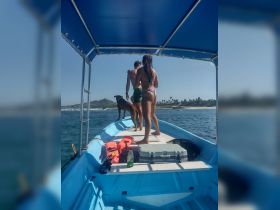 A couple enjoys a sunny day on a boat with their dog, capturing the essence of fun and relaxation on the water.