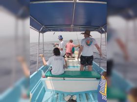 A group of friends enjoys a fishing trip on a boat, casting lines into the open ocean — a perfect day for adventure and camaraderie.