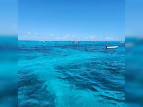 A stunning view of turquoise waters dotted with boats, perfect for island hopping adventures in a tropical paradise.