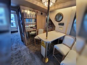 Interior view of a cozy boat cabin featuring a dining area and seating, perfect for relaxing and enjoying meals while on the water.