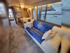 Interior view of a cozy lounge area on a boat, featuring comfortable seating and nautical decor, perfect for relaxing during a day on the water.