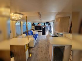 Interior view of a spacious boat cabin featuring comfortable seating and modern amenities, perfect for relaxing during a day on the water.