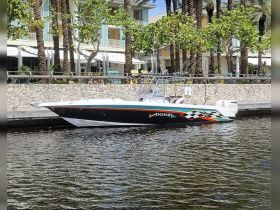 A sleek speedboat docked along a waterfront, showcasing its vibrant design and the surrounding lush palm trees — perfect for a day on the water.