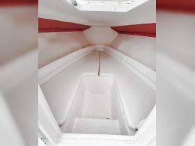 Interior view of a boat cabin featuring spacious white seating, ideal for relaxing while on the water.