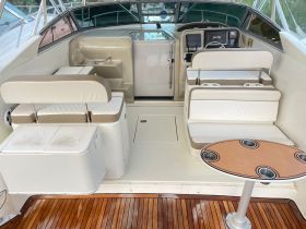 The interior of a well-appointed boat cabin featuring comfortable seating and a helm area, ideal for relaxing and navigating on the water.