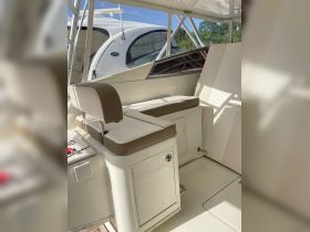 Interior view of a boat's helm area featuring comfortable seating and a clean, modern design, perfect for relaxing while navigating the waters.