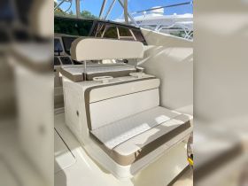 A well-designed seating area inside a boat's helm, featuring comfortable cushions and cup holders, perfect for relaxing while navigating the waters.